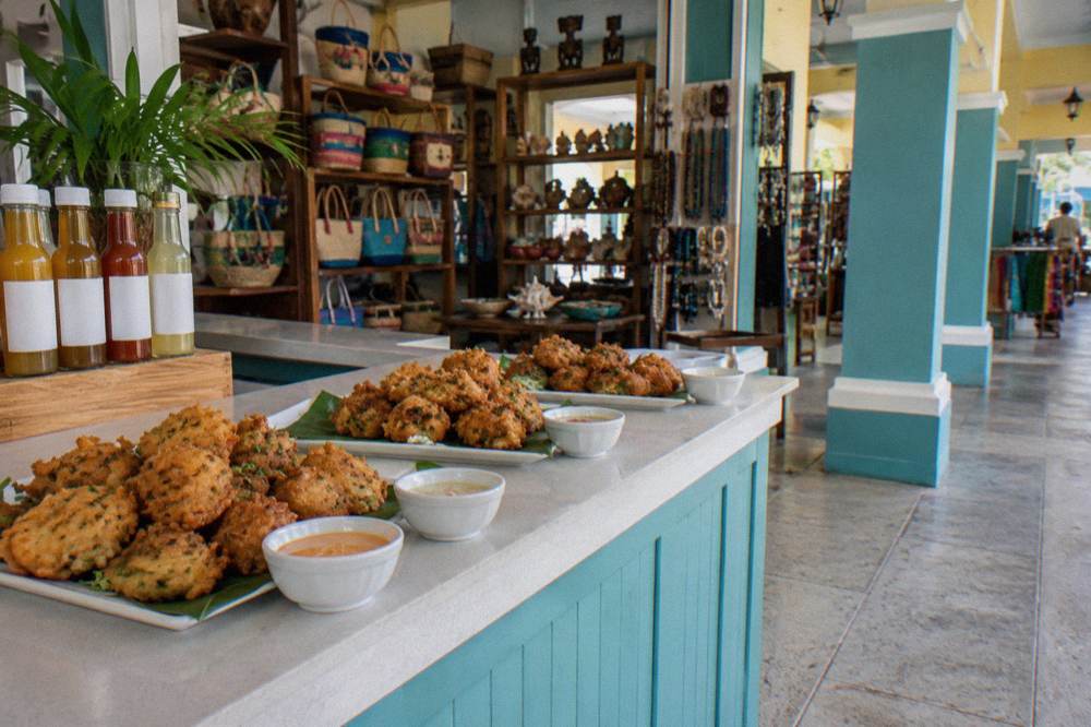 A cooking class table with conch fritters frying in a pan and cocktail glasses waiting