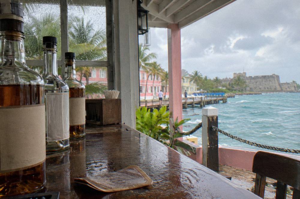 A row of labeled rum bottles arranged on a tasting bar in an estate tavern