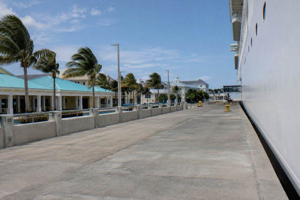 Cruise ship docked at a Nassau wharf with downtown buildings behind it