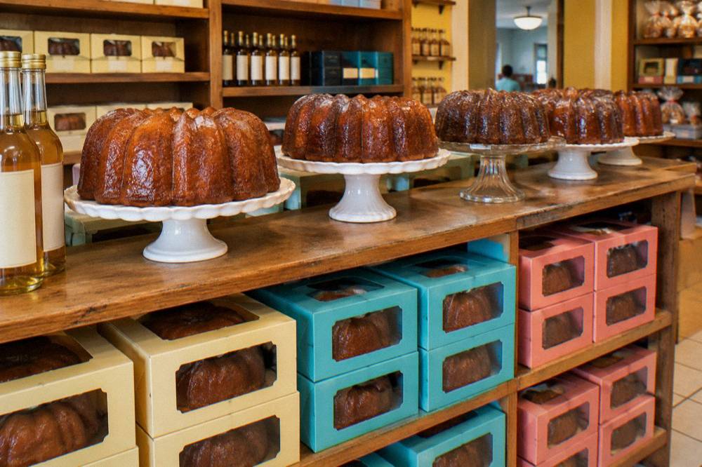 Display shelf of boxed rum cakes inside a bright Nassau bakery shop