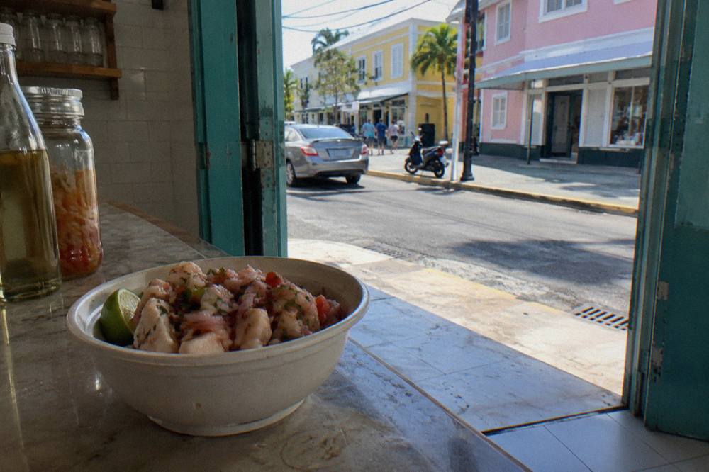 Close-up of a fresh conch salad with lime, tomato and pepper in a bowl on a market counter