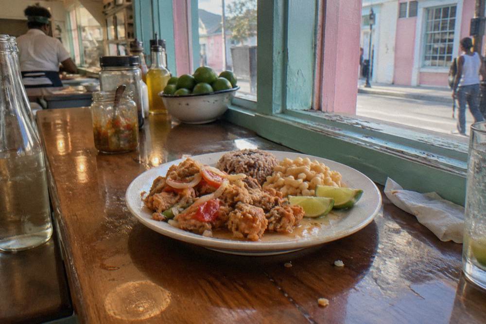 Fried cracked conch fillets with peas and rice and lime on a plate