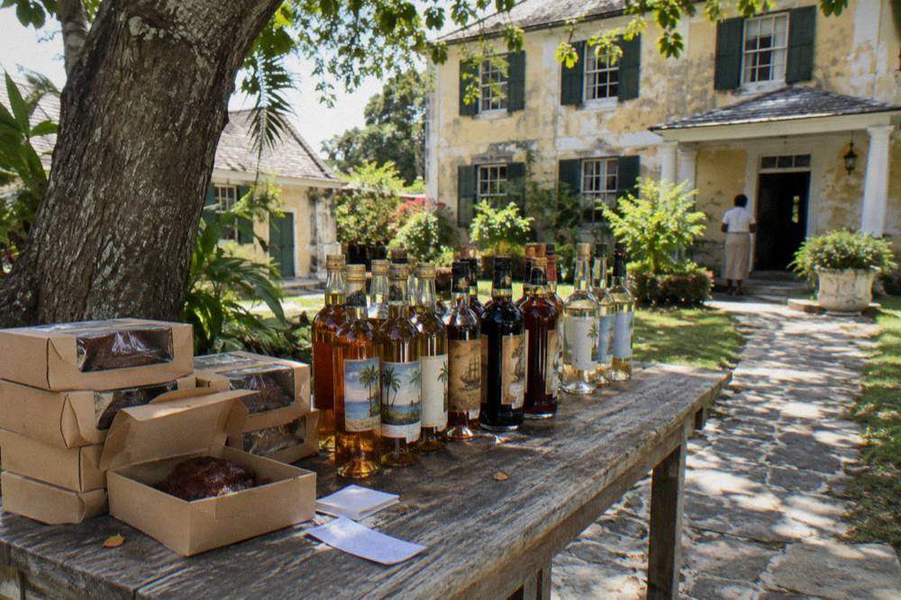 Boxed rum cakes and bottles of rum arranged on a distillery shop shelf