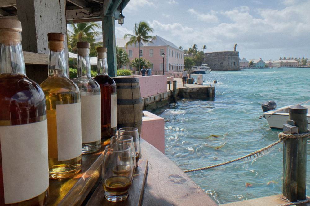 Colorful rum bottles arranged above a distillery tasting bar in Nassau