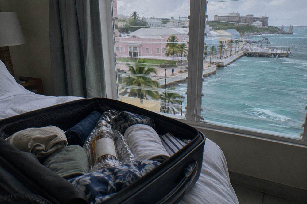 A wrapped liquor bottle packed in the middle of a hard-sided suitcase