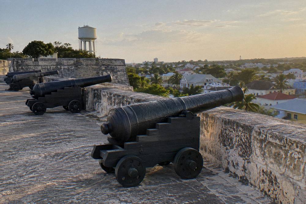A stone fortifications wall overlooking Nassau harbor from a hilltop