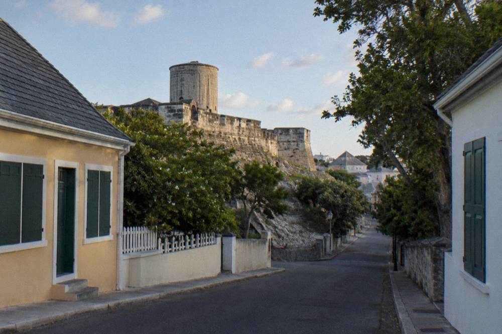 A historic Nassau street climbing uphill past pastel colonial buildings