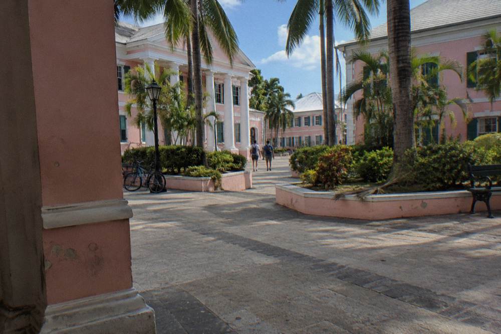 A guided walking group gathered outside a historic Nassau building on a sunny afternoon