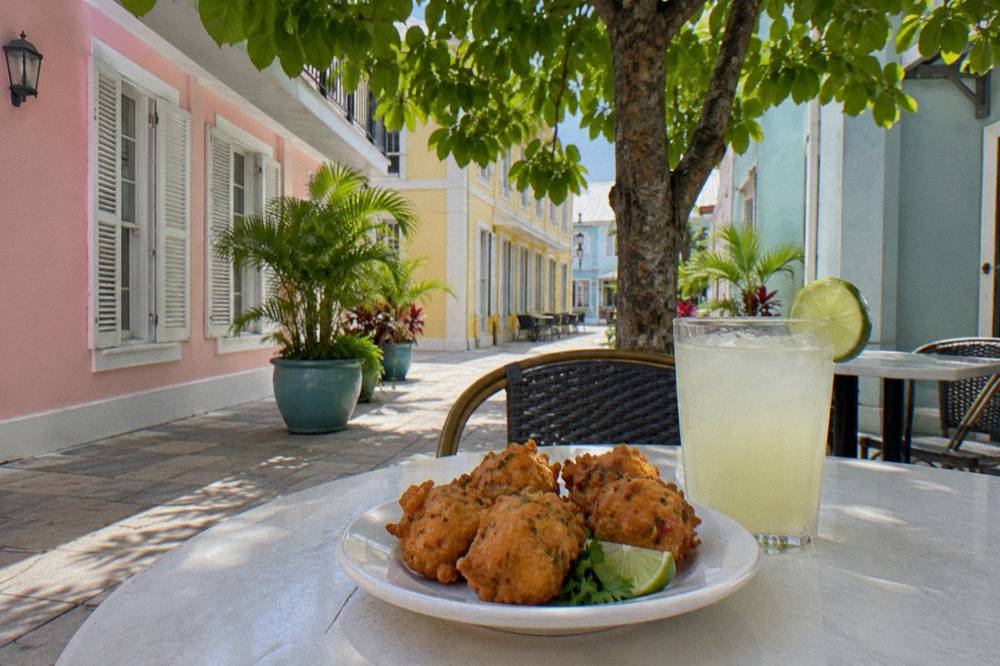 Golden conch fritters served on a plate at an outdoor Nassau eatery