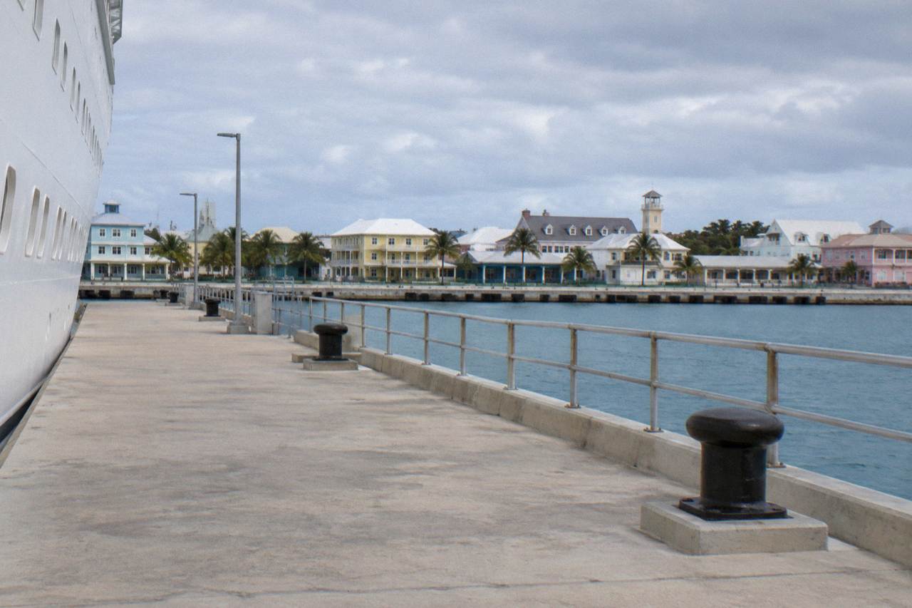 Cruise ships docked at Prince George Wharf with downtown Nassau buildings behind them