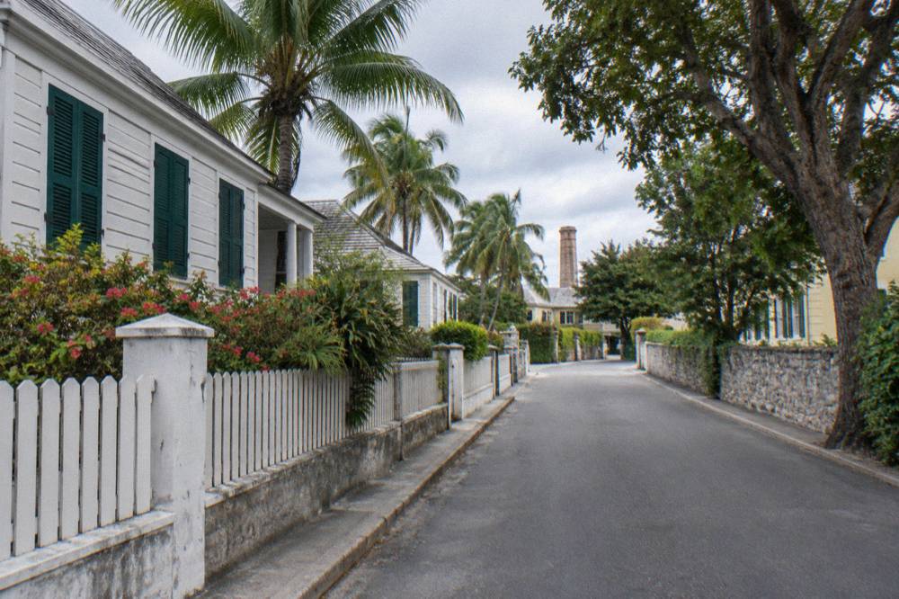 Tropical gardens and a stone path beside a historic Nassau estate building