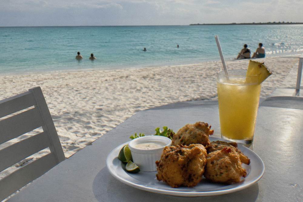 Plates of conch fritters and appetizers set on a restaurant table