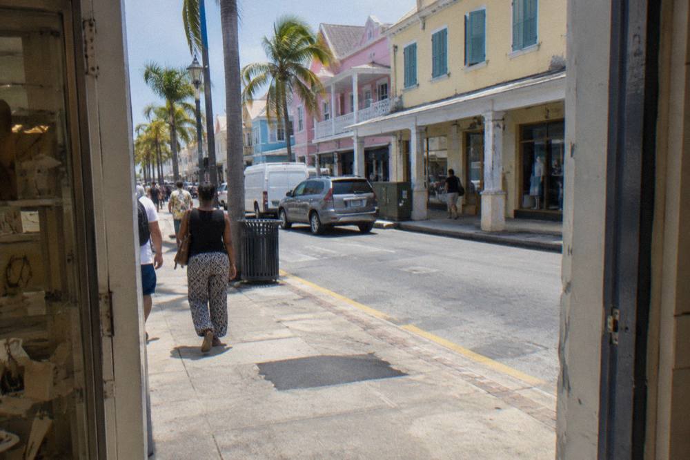 A painted van parked on a Nassau street beside colonial stone buildings