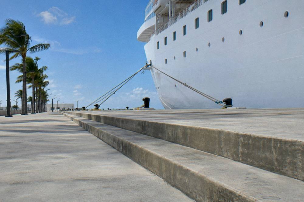 A cruise ship docked at a wharf beside a waterfront terminal building