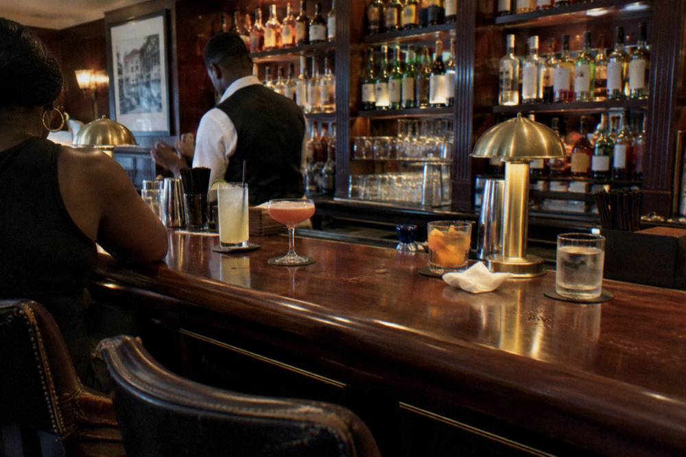 Empty cocktail lounge with leather stools and warm lighting before a private class