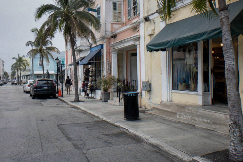 Guided tour group walking past colonial-era buildings on a sunny Nassau morning
