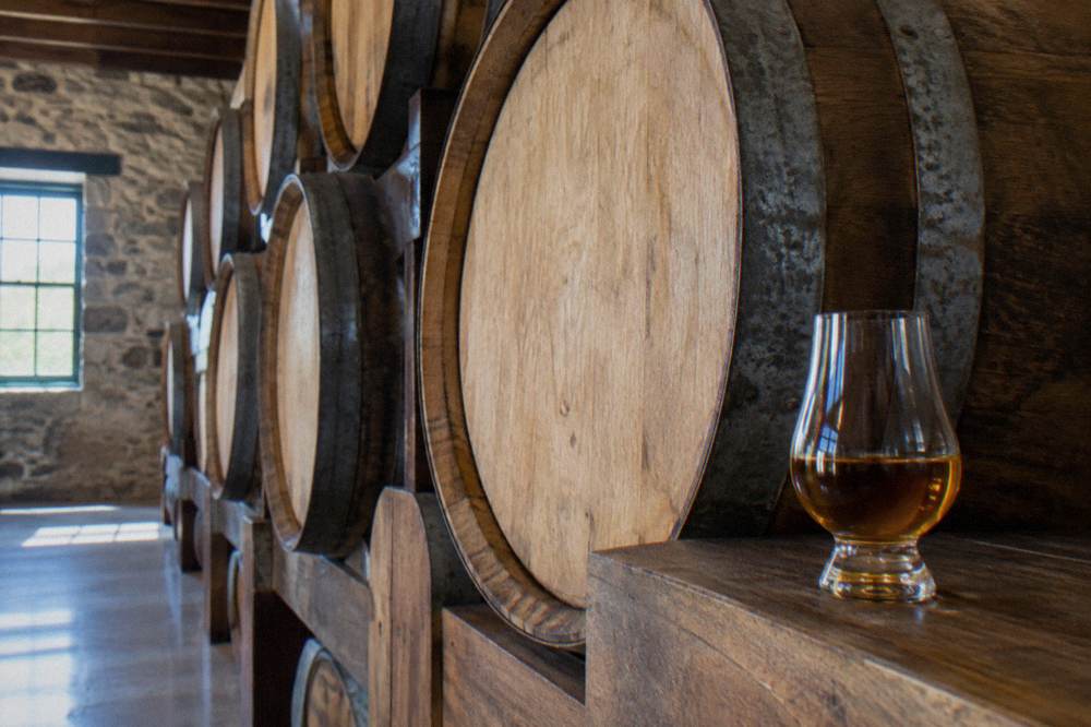 Wooden rack of aging rum barrels inside a distillery storehouse