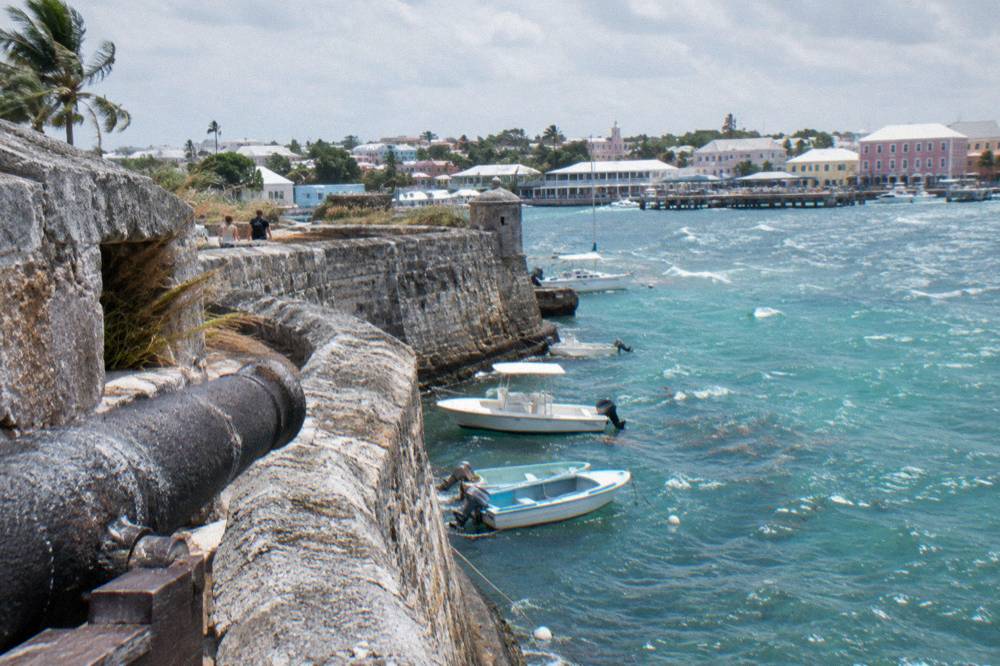 Weathered stone fortification wall overlooking Nassau harbor and moored boats