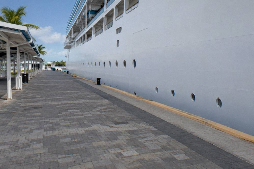 Cruise ship docked at a wharf with pastel colonial buildings beyond