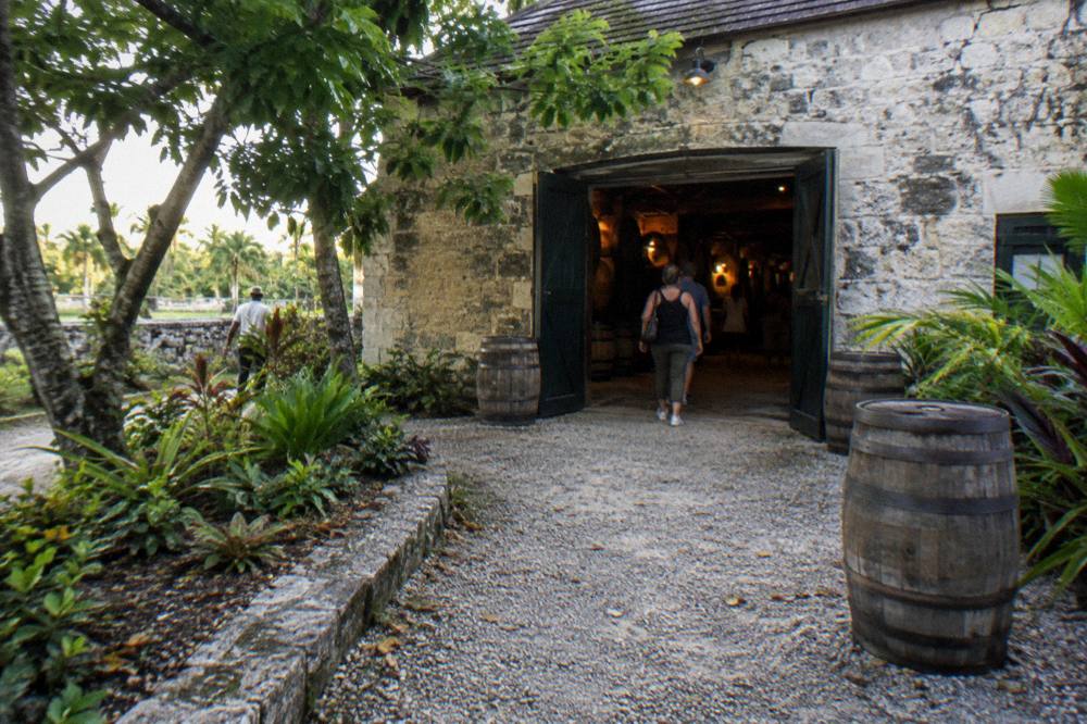 Rum barrels stacked in a stone storehouse lit by warm light