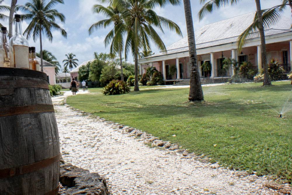 Sunlight on the lawn and palms of a historic colonial estate building