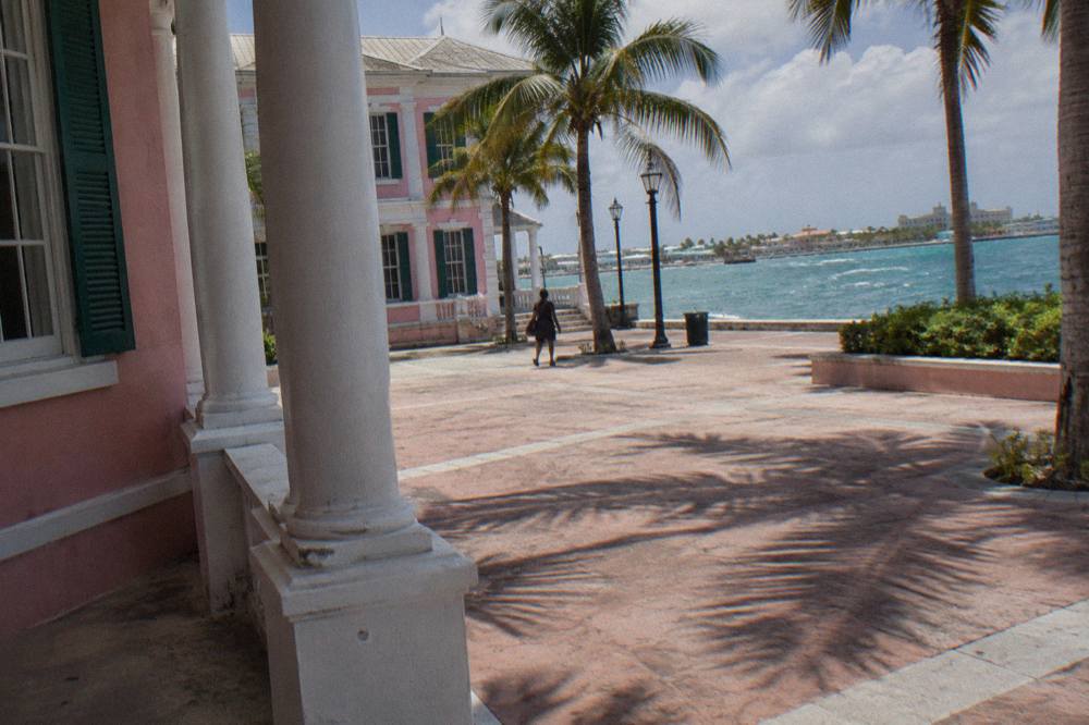 Pastel colonial government buildings around a square with palm trees near the cruise port