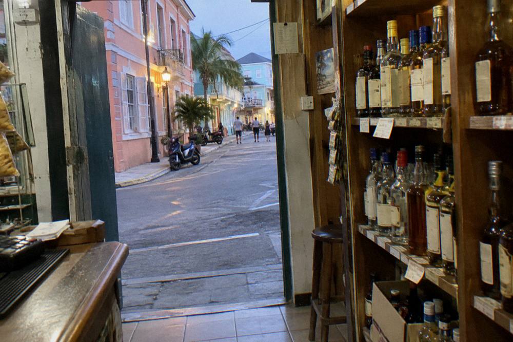 Rum bottles and a sealed bottle packed in a carry bag on a shop counter