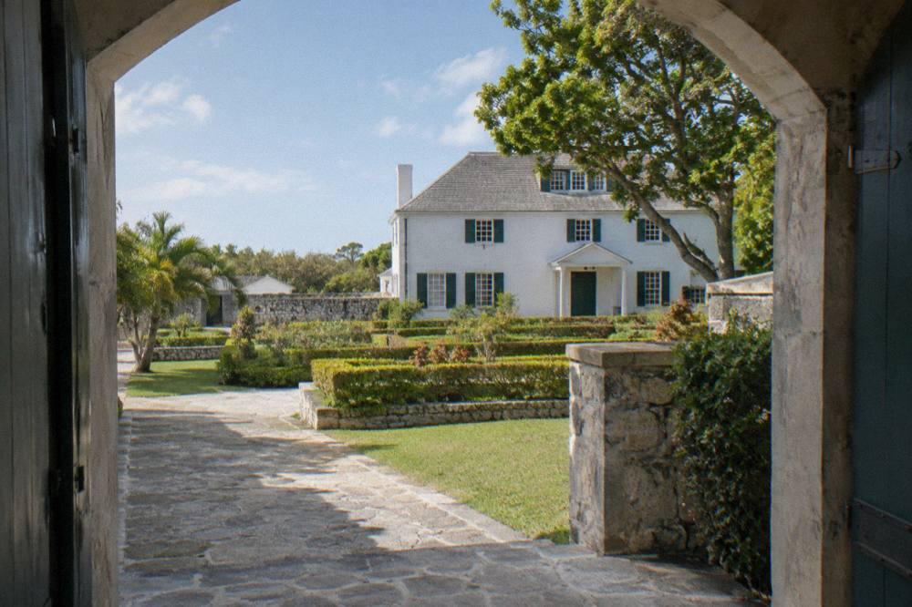 Historic stone distillery building surrounded by tropical gardens and palm trees