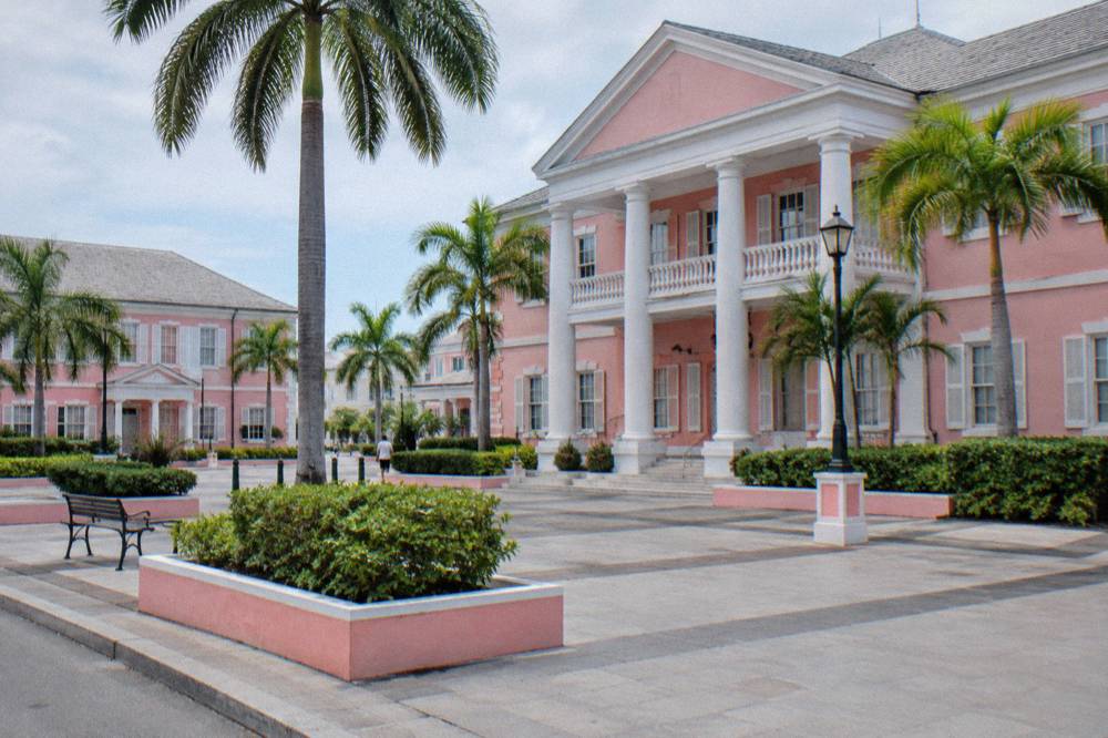 Pastel colonial government buildings along a downtown street with palm trees