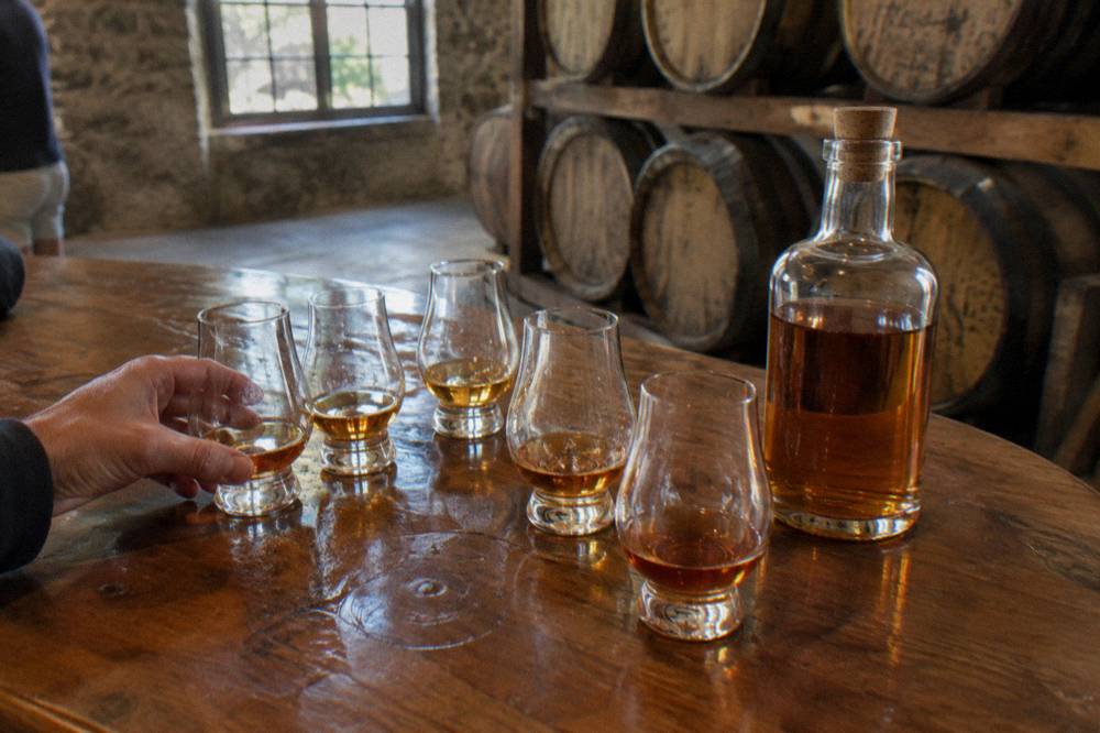 Distillery courtyard with aging rum barrels and a colonial building facade