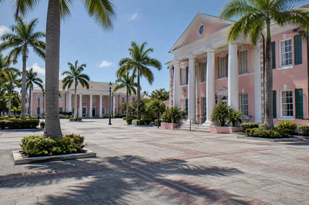 Pastel colonial buildings along a downtown Nassau street with palm trees